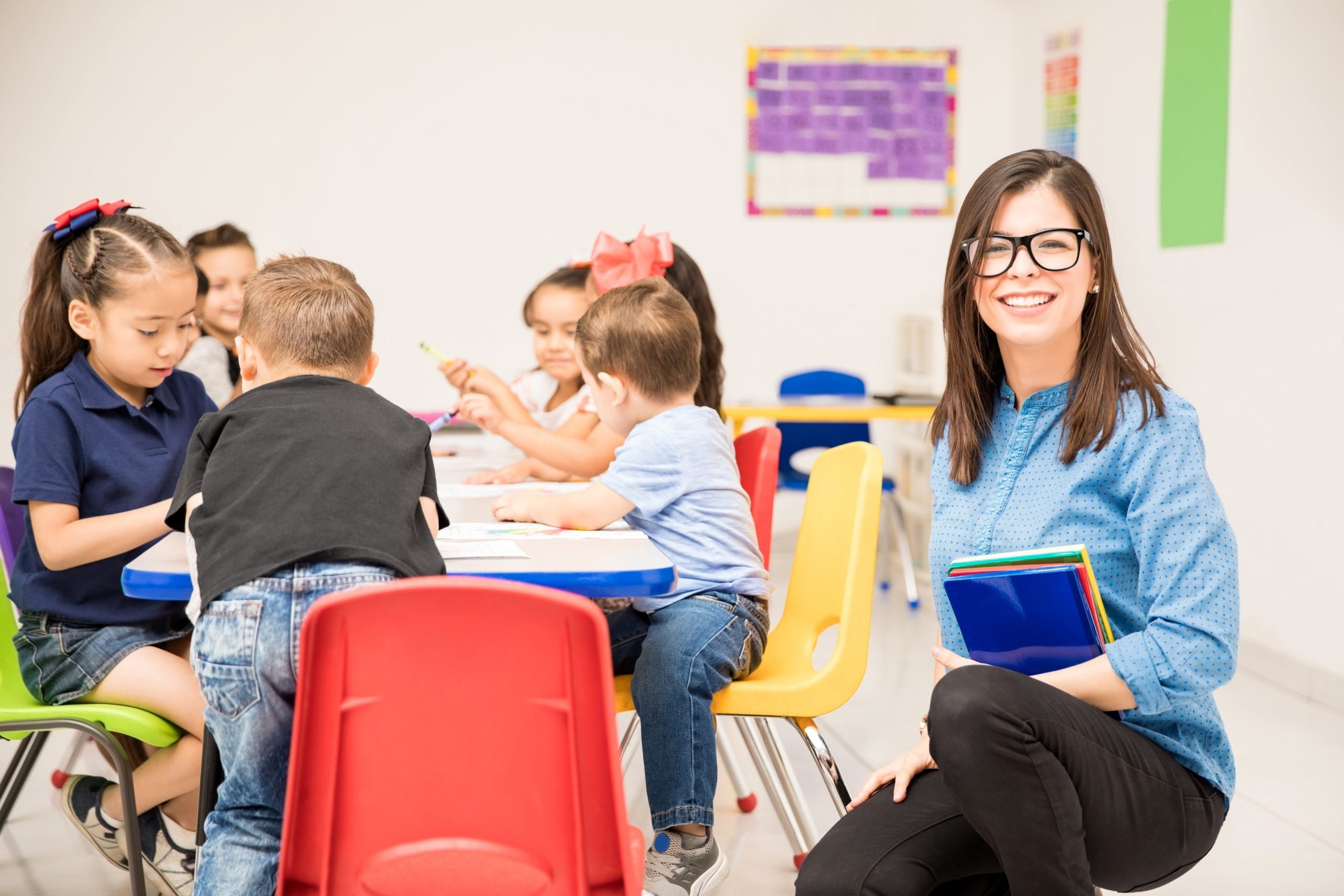 person smiling with children in school setting